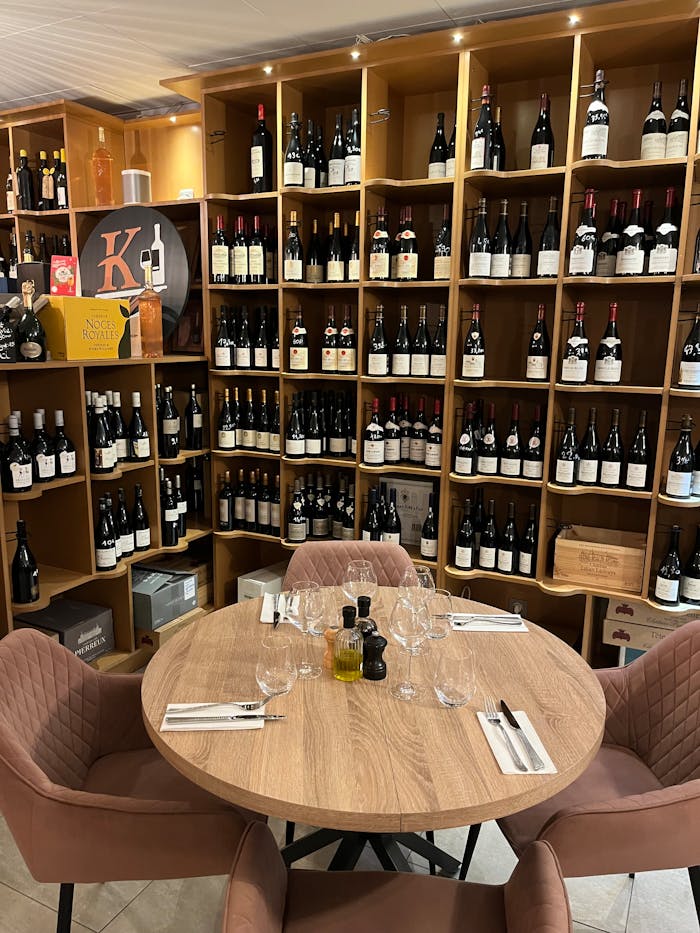 Intimate table setting in a French wine cellar. Explore the rich wine selection.